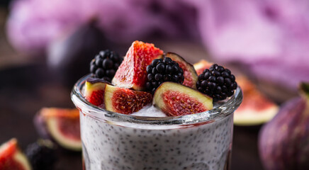 Healthy chia pudding with figs and blackberries in glass on the rustic background. Selective focus. Shallow depth of field.