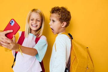 school children looking at the phone entertainment communication yellow background