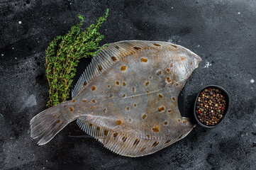 Raw flounder flatfish fish on marble board with thyme. Black background. Top view