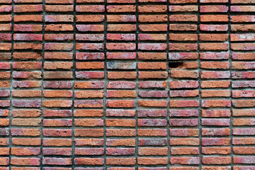 1 broken brick surrounded by red bricks that are lined up as walls.