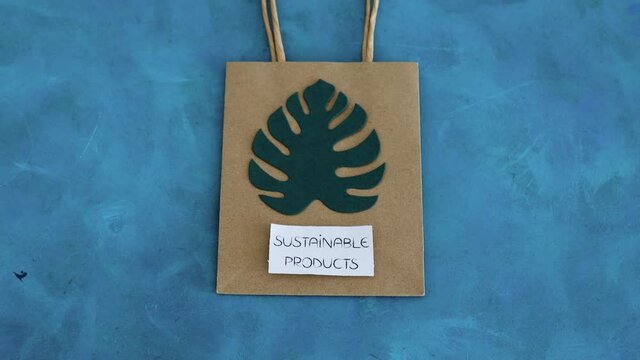 environmental awareness and consumer behaviour conceptual image, Sustainable Product text on shopping bags with tropical green paper leaves on them