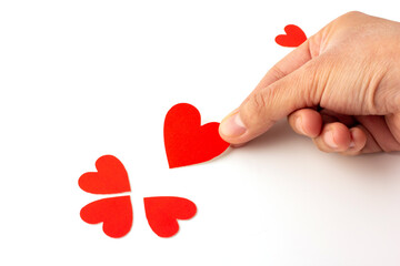 Hand holding heart shaped red paper isolated on a white background, concept love and valentine's day.