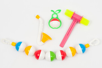 Colorful plastic baby rattles. Pacifier, hammer, bell and suspension for a stroller.