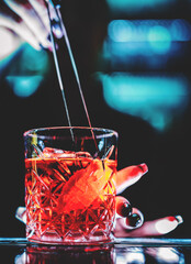 woman bartender hand making negroni cocktail. Negroni classic cocktail and gin short drink with...