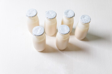 Small bottles with probiotics and prebiotics dairy drink on white background. Production with biologically active additives. Fermentation and diet healthy food. Bio yogurt with useful microorganisms.