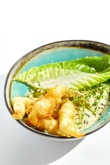 Delicious appetizers - tempura shrimp with peanut sauce. Japanese dish - crispy deep fried prawn. Tempura prawn with asian sauce isolated on white background. Hot deep fried seafood appetizer.