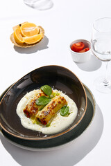 Italian beef cannelloni with bolognese ragu, bechamel sauce and cheese. Baked pasta cannelloni with meat and cheese parmesan. Italian aesthetic white table. Harsh shadow in Italian menu restaurant.