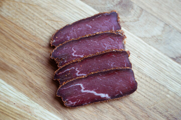 Beef basturma on a board with spices