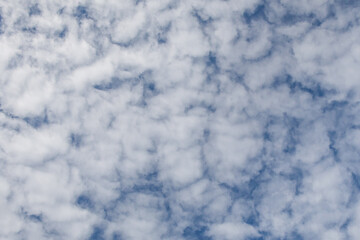 Fragment of the blue sky with white clouds. Textured abstract background