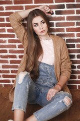 Young beautiful woman with long hair in jeans and cardigan