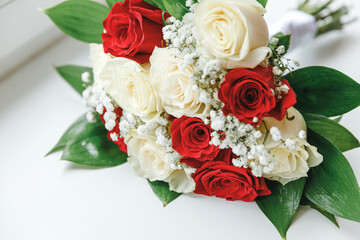 Beautiful wedding bouquet of flowers in white red colors lying on white surface background. Declaration of love, spring. Wedding card, Valentine's Day greeting. Wedding day details.