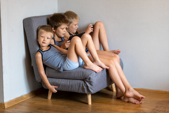 Three brothers fit in one small chair