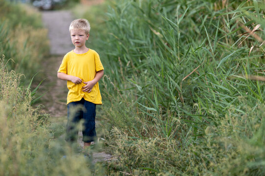 .Little boy descends to river along path