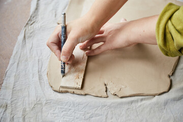 Female ceramist working in pottery studio. Ceramist's Hands Dirty Of Clay. Process of creating...