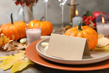 Beautiful autumn place setting with blank card and decor on wooden table