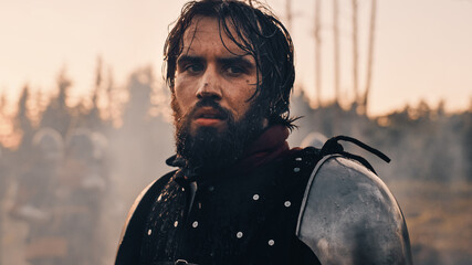 Handsome Medieval Knight King on Battlefield, Looking at Camera. Portrait of Mighty Warrior Soldier...