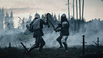 Epic Battlefield: Two Armored Medieval Knights Fighting with Swords. Dark Ages Army Warfare. Action Battle of Armed Warrior Soldiers, Killing Enemy. Cinematic Historical Reenactment. - obrazy, fototapety, plakaty