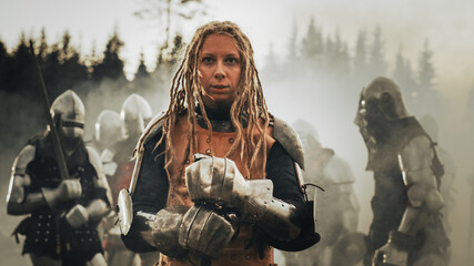 Epic Battlefield: Portrait of Powerful Female Leader Warrior Holding Sword, Ready for Battle. Woman...