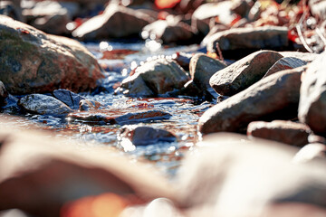 View of the mountain river with stones and rocks. Shallow depth of field. Blurry bokeh