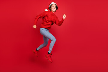 Full size profile side photo of young girl happy positive smile fast go walk runner eve time isolated over red color background