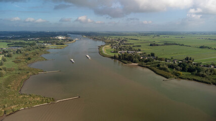 Inland container barge on River Lek aerial view near the village of Bergambacht, South Holland, Netherlands