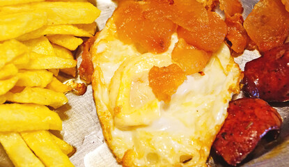 Plato combinado de huevos fritos con patatas fritas y chorizo