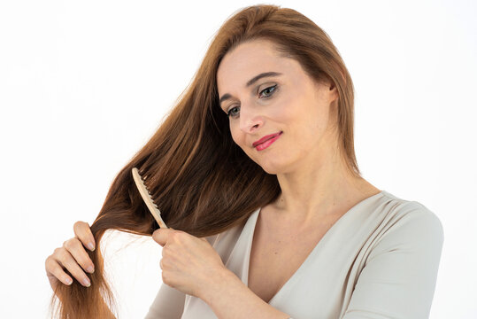 woman combing long brown healthy hair, natural skin