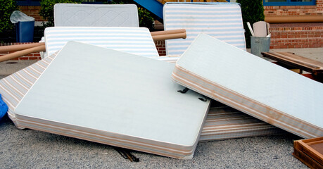 Pile of old motel mattresses, boxsprings and frames.