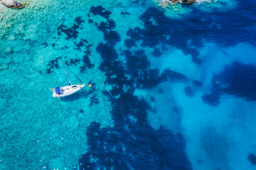 Aerial view of lonely yacht boat in secluded remote beach on the Ionian island of Kefalonia, Greece