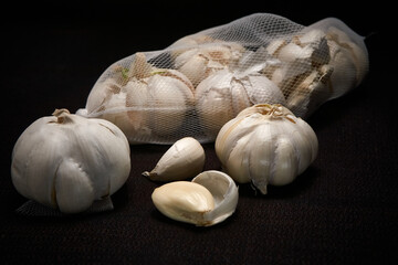 Head and mesh of garlic on a dark background