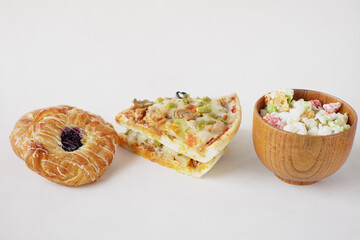 Slice of cheese pizza on a plate , donuts and popcorn on white 