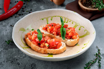 bruschetta with chopped tomatoes, basil and pesto sauce on a plate