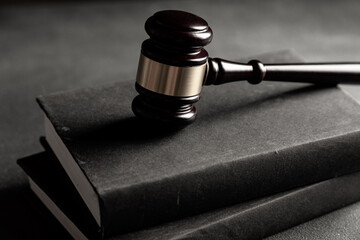 Law theme, judge gavel on a dark table with a book.