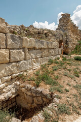 A girl in a dress travels to the ancient ruins of the fortress. Tourism in Crimea.