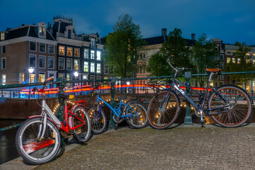 Fototapeta premium Bicycles on the Canal Embankment in Amsterdam at Night