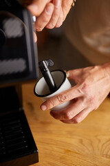 An Anonymous Barista Making a Cappuccino in a Coffee Chop, Male barista hand making espresso from ground coffee maker at modern cafe