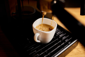 Detail of a professional coffe maker dripping coffe into an empty cup in a cafeteria, Machine is making a perfect coffee with delicious smell, . Espresso Coffee Machine Making Espresso Coffee