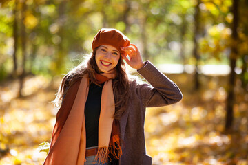 Happy smiling woman in orange beret in autumn forest