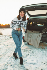 young pretty woman near suv car with opened trunk on sunset