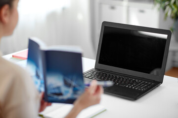 distant education, school and people concept - female math teacher laptop computer and book having online class at home