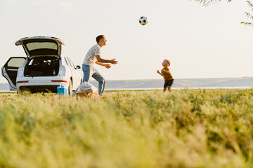 Young white father and son playing football together