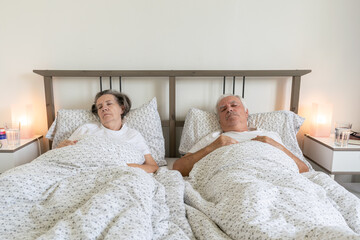 senior aging married couple man male and female woman deep sleep resting together in bed relationship love