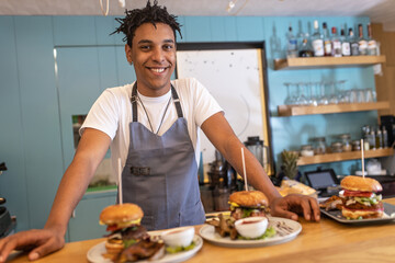 Portrait of young waiter.He standing in his bar and looking at camera.	
