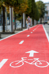 traffic, city transport and people concept - woman cycling along red bike lane with signs of bicycles on street