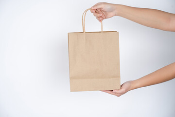 Reduce, Paper bag in male hands over grey background.