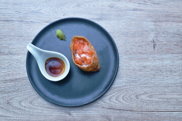Inari salmon Sushi Japanese food made from rice wrapped by fried tofu with wasabi dipping soy sauce on plate