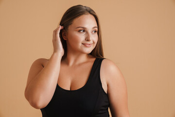 Fototapeta premium Young woman wearing swimsuit smiling and looking aside