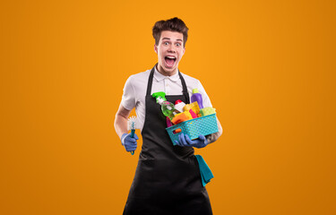 Excited male housekeeper with cleaning supplies