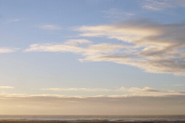 Sunlit Clouds at Dawn on Bright Blue Sky Ocean and Sandy Beach