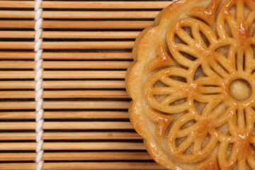 Colorful flower decorated mooncake Chinese mid autumn festival on bamboo food mat background